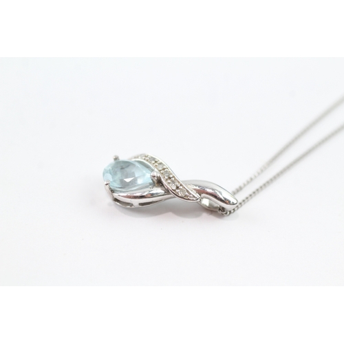 92 - 9ct white gold diamond and blue gemstone twist pendant on chain (2g)