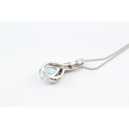 92 - 9ct white gold diamond and blue gemstone twist pendant on chain (2g)