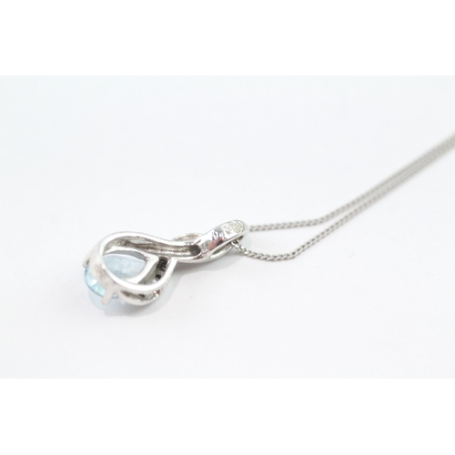 92 - 9ct white gold diamond and blue gemstone twist pendant on chain (2g)