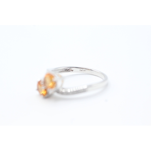 142 - 9ct white gold diamond and orange diopside set bypass ring (2.5g) Size N