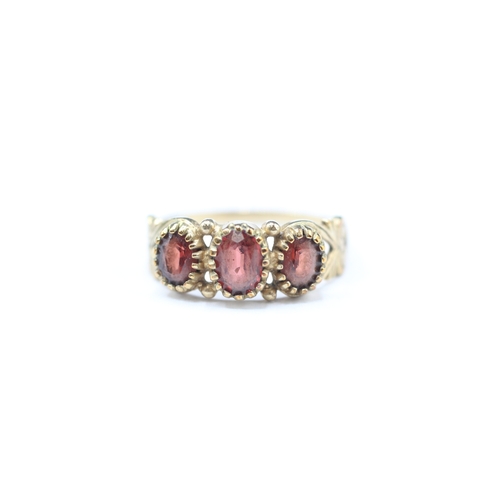 178 - 9ct gold garnet three stone ring (2.1g) Size N