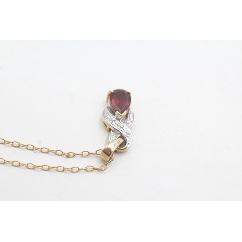 96 - 9ct gold single garnet & diamond by pass pendant necklace (2.8g)