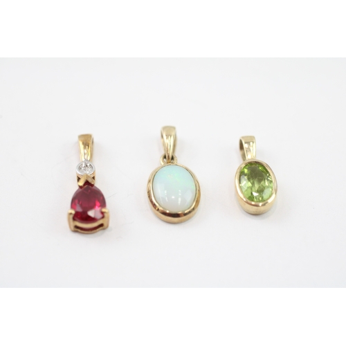 32 - 3 x 9ct gold synthetic ruby, diamond, peridot and opal pendants (2.3g)