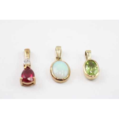 32 - 3 x 9ct gold synthetic ruby, diamond, peridot and opal pendants (2.3g)