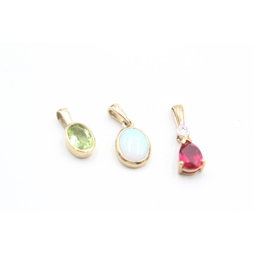 32 - 3 x 9ct gold synthetic ruby, diamond, peridot and opal pendants (2.3g)
