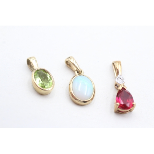 32 - 3 x 9ct gold synthetic ruby, diamond, peridot and opal pendants (2.3g)
