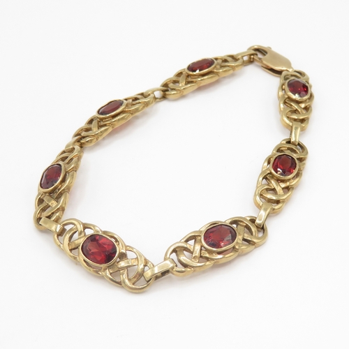 279 - 9ct gold garnet set Celtic link bracelet (13.6g)