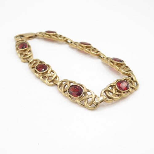 279 - 9ct gold garnet set Celtic link bracelet (13.6g)