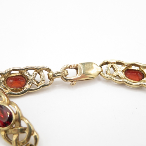 279 - 9ct gold garnet set Celtic link bracelet (13.6g)