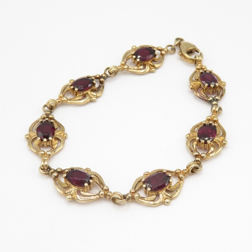 287 - 9ct gold garnet set spider link bracelet (11g)