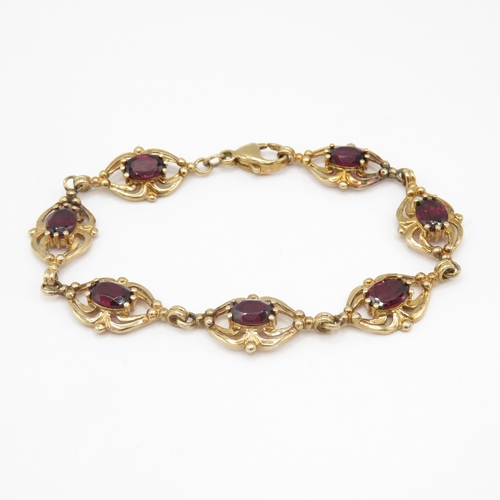 287 - 9ct gold garnet set spider link bracelet (11g)