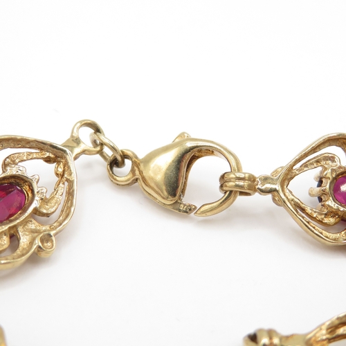 287 - 9ct gold garnet set spider link bracelet (11g)