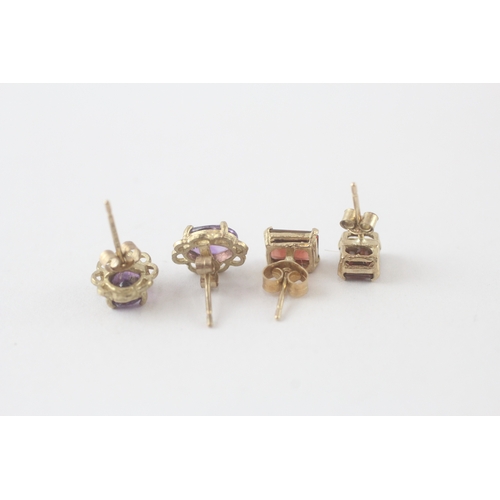 87 - 2x 9ct gold amethyst |& garnet stud earrings (2.7g)