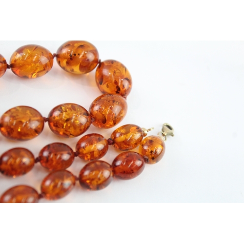 98 - 9ct gold amber necklace (51.9g)