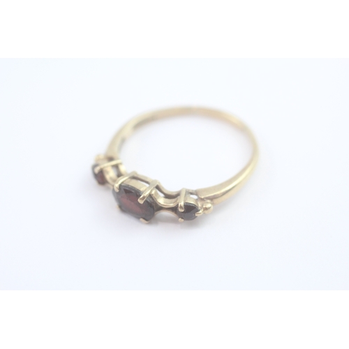89 - 9ct gold garnet trilogy ring (2.2g) Size R