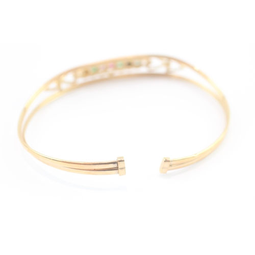 24 - 9ct gold acrostic 'DEAREST' bangle, including diamond emerald ruby sapphire (5g)