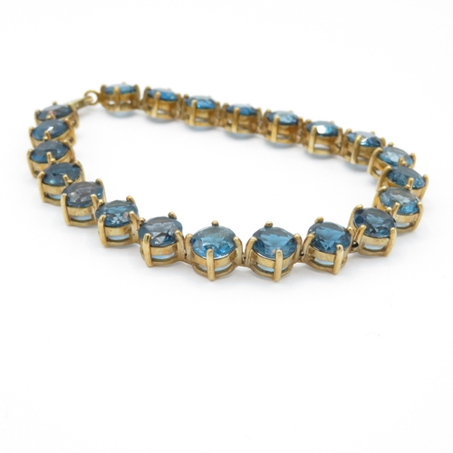 7 - 9ct gold blue topaz line bracelet (19.4g)