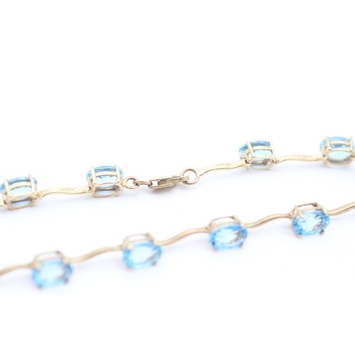 4 - 9ct gold blue topaz set station bracelet (6g)