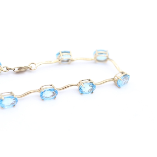 4 - 9ct gold blue topaz set station bracelet (6g)