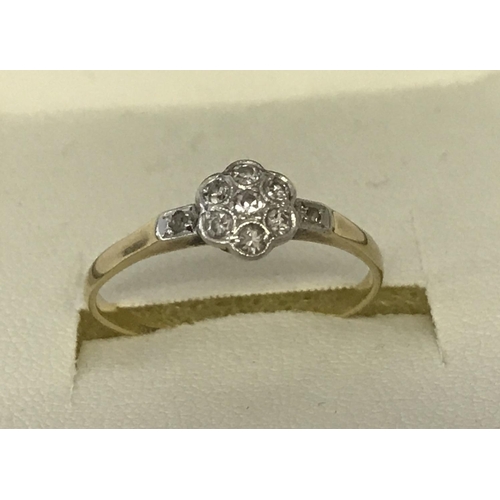 10 - A diamond set 18ct gold and platinum dress ring of flower head design. Small central round cut diamo... 
