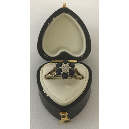 27 - A 9ct gold sapphire and diamond dress ring. Central small diamond surrounded by 6 sapphires. Ring si... 