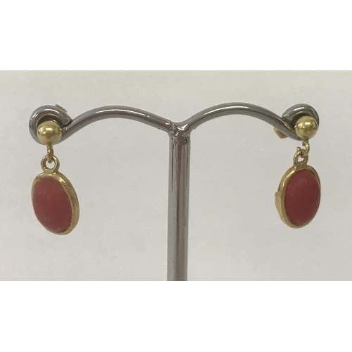 5 - A pair of coral set,small oval, drop style earrings. Tests as 22ct gold.
