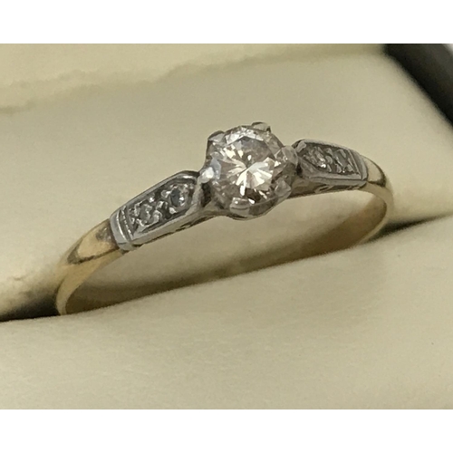 54 - A vintage 18ct gold diamond solitaire ring. Central diamond approx .2ct with two small diamonds to e... 