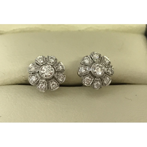 1004 - A pair of 18ct white gold & diamond set, flower design stud earrings by Luke Stockley, London. Each ... 