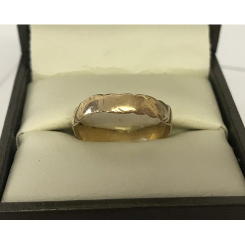 1036 - A 9ct gold vintage wedding band. Scalloped edge design with worn pattern to outside. Ring size O. To... 