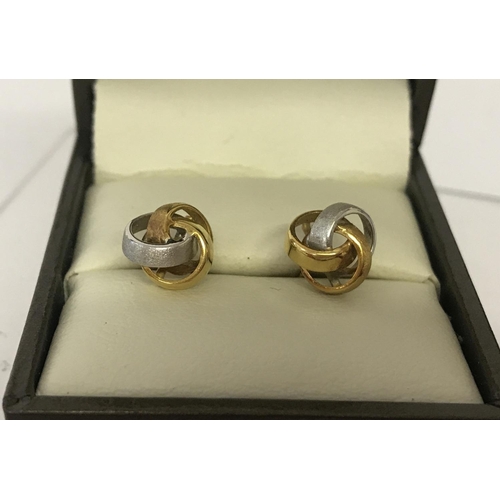 1037 - A pair of duo coloured 18ct gold knot style earrings. Butterfly backs missing.  Total weight approx.... 