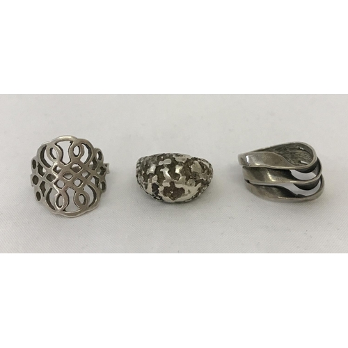 1136 - 3 modern design silver dress rings. Comprising: a rough cast effect dome style ring marked 