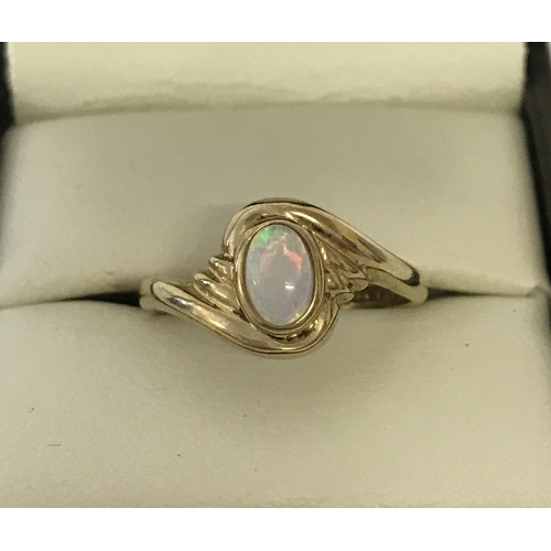 1162 - A 9ct gold dress ring set with an oval cut cabochon opal. Twist style decorative mount. Size N. Tota... 