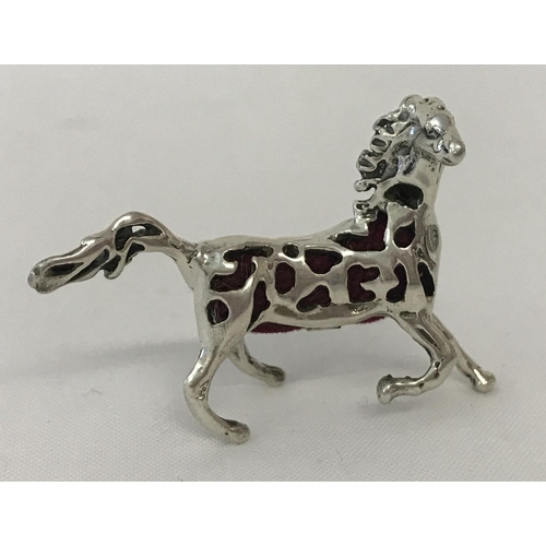 1186 - A small sterling silver horse shaped pin cushion with pierced work detail and red velvet cushion.  A... 