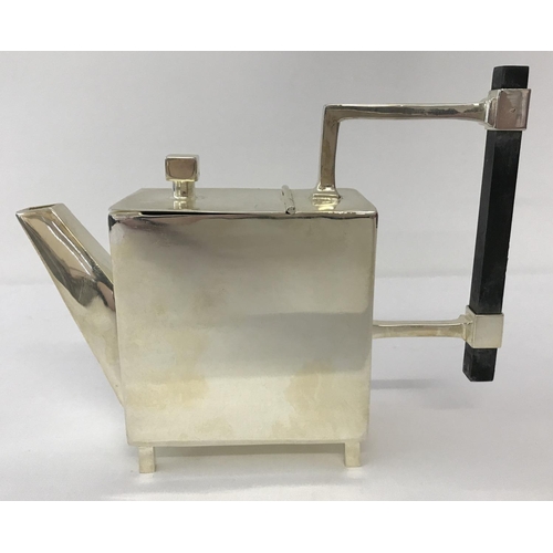 1198 - A silver plated Christopher Dresser style teapot of Art Deco design. Of square form, raised on 4 squ... 