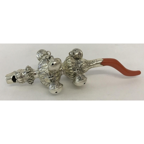 1207 - A decorative white metal babies rattle with whistle and coral handle/teether. Whistle mouthpiece mar... 