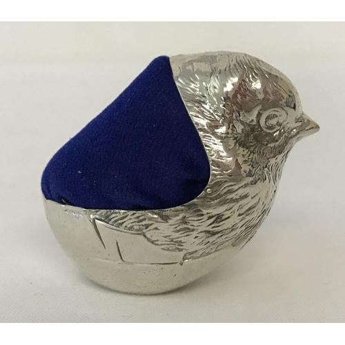 1210 - A 925 silver pin cushion in the shape of a chick hatching from an egg. With blue velvet cushion. Hal... 