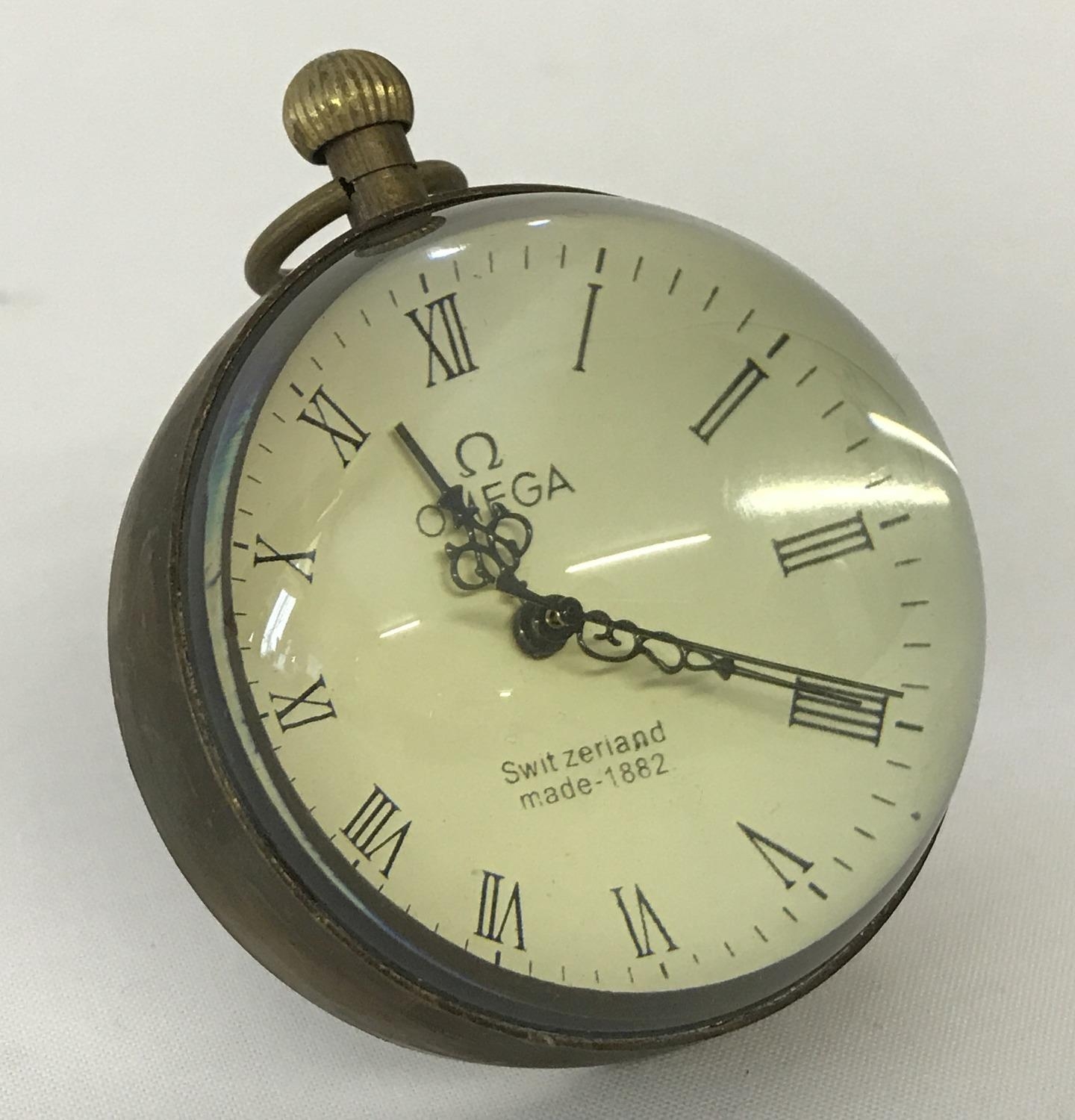 A small Omega design glass ball watch bound in brass with roman