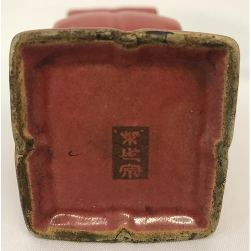 1322 - A square shaped Chinese ceramic vase with red glaze and channelled detail. Signed to underside. Appr... 