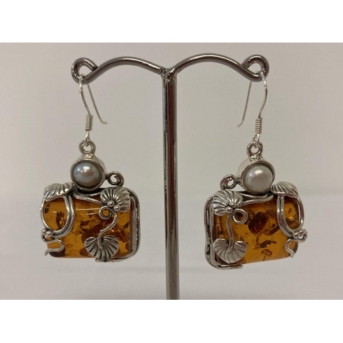 1035 - A pair of silver mounted Art Nouveau style drop earrings set with amber and pearl.  Approx. 4cm tota... 