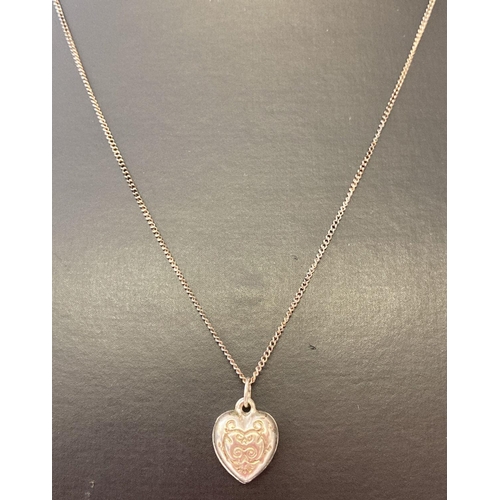 1047 - A decorative silver heart shaped pendant on an 18