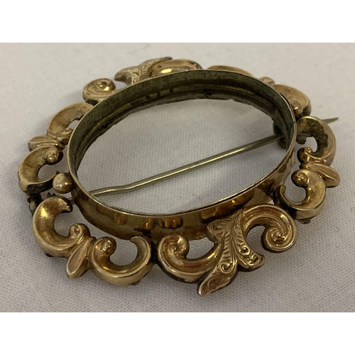 1073 - A decorative Victorian gold mourning brooch mount, tests as 9ct gold. Pin back, fastening hook and i... 