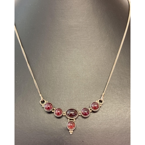 1092 - A pendant style silver necklace set with 6 round and oval cabochon garnets. Marked '925' to back of ... 