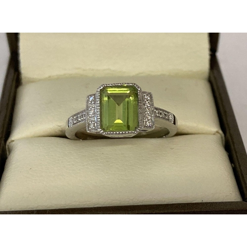 1096 - A 9ct white gold Art Deco style peridot and diamond dress ring probably by Luke Stockley, London. Ce... 