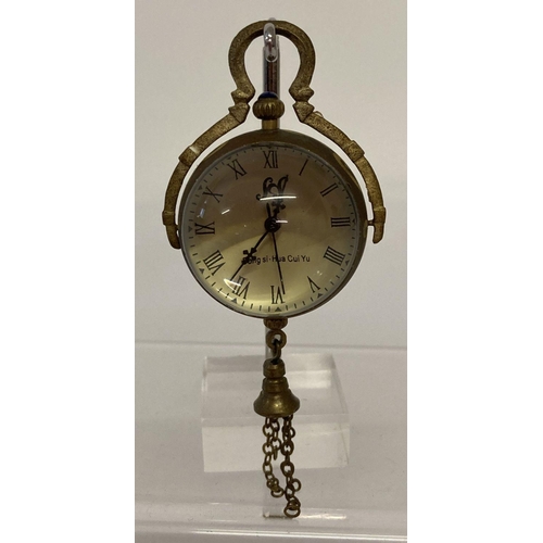 1118 - A brass bound ball watch pendant with tassel detail.  Approx. 3cm diameter.