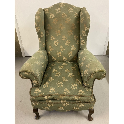 1609 - A vintage wing back chair with green & gold upholstery and wooden cabriole feet.