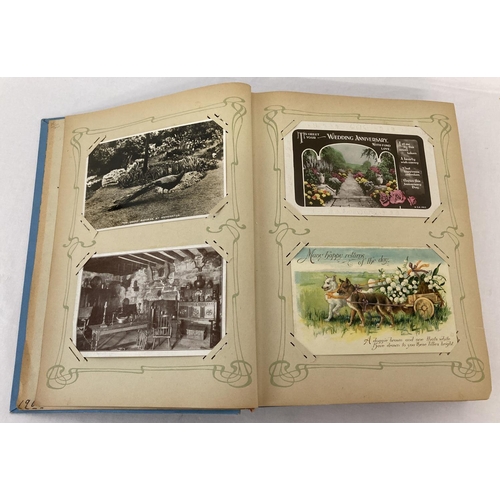 162 - A vintage blue Art Nouveau postcard album containing a quantity of cards. To include: greetings card... 