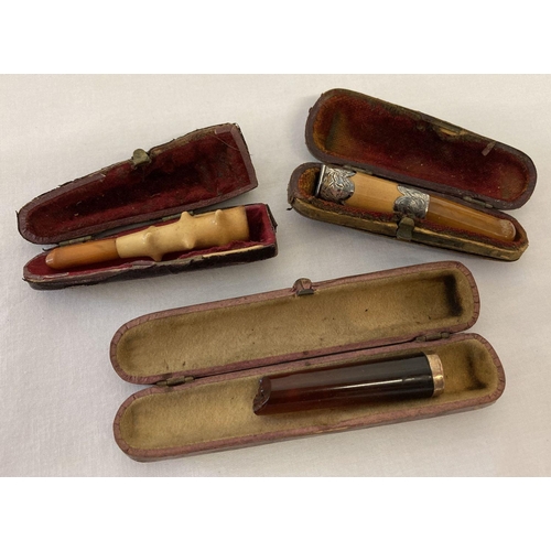 438 - 3 cased vintage cheroot holders. One with decorative white metal collar. One a/f.