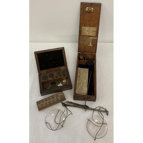 439 - A wooden cased set of Victorian apothecary scales with glass trays and weights.  Together with a box... 