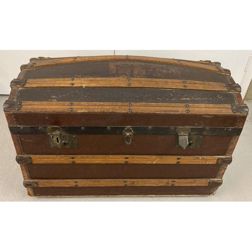 444 - A Victorian dome top, wooden banded travelling trunk on metal casters.  Complete with original inter... 