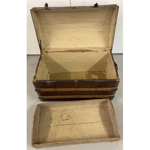 444 - A Victorian dome top, wooden banded travelling trunk on metal casters.  Complete with original inter... 